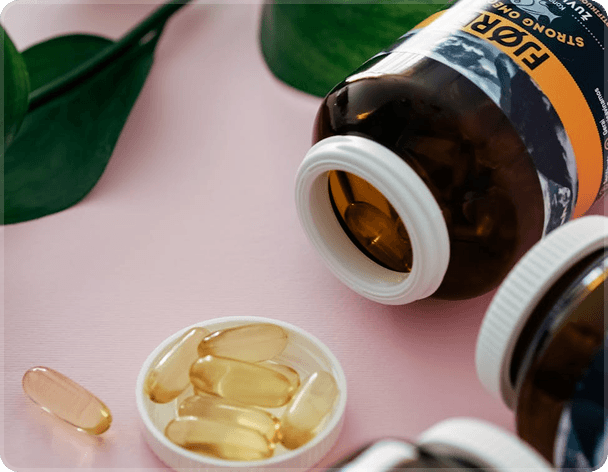 Supplement bottles and capsules on a soft pink surface, representing quality and transparency in health products